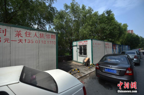 Mobile phone numbers and rent price are painted on the makeshift containers at a construction site near Jintai Road, Chaoyang district of Beijing. (Photo/Chinanews.com)
