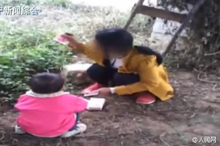 A woman in southern China's Hengxian County, Guagnxi Zhuang Autonomous Region, counts money in her daughter's face while selling her.  (Photo/people.com.cn)