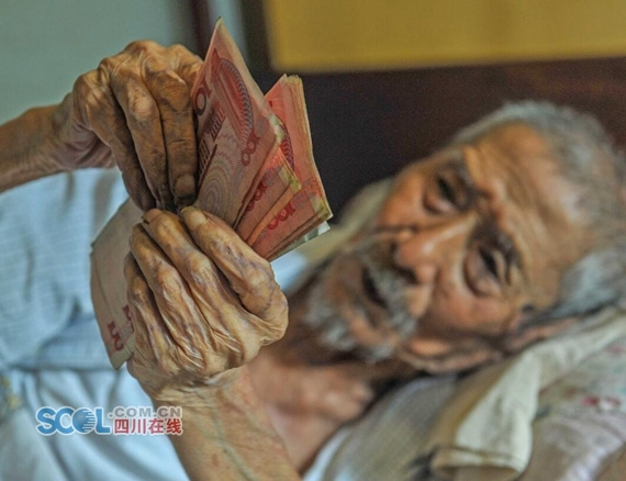 Lin Yongqing, 103, likes counting banknotes in bed. (Photo/scol.com.cn)