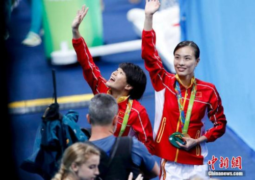 Chinese diving star Wu Minxia (R) waves her hand at the awarding ceremony of women's SYNC.3M Springboard in Rio de Janeiro, Brazil, on Aug. 7, 2016. (Photo/Chinanew.com.cn)