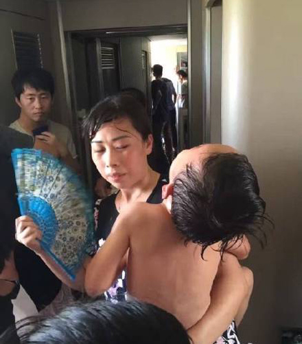 A little boy is drenched in sweat on a high-speed train from Beijing to Shenzhen after it is stranded on the track for nearly two hours due to a power failure on Aug. 12. (Photo from Weibo)