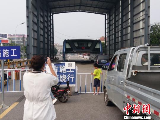 A woman from Beijing takes photos of the test site of Batie at Qinghuangdao, Hebei province, Aug. 24, 2016. (Photo/Chinanews.com)