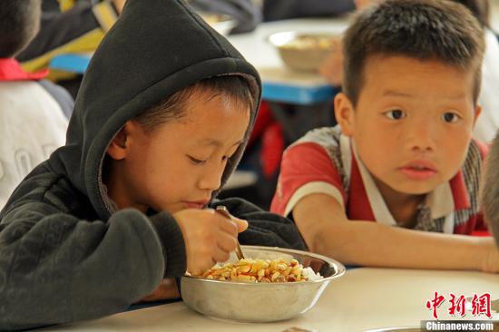 Children have their meal provided by government-funded program. (File photo/Chinanews.com)