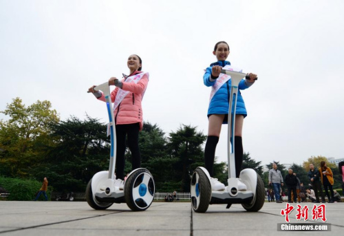 Two girls ride Segways on the road. (File photo/Chinanews.com)