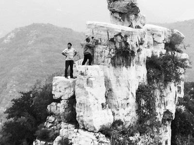 Chen Zhicheng cleans up the graffiti he wrote at a scenic spot in Beijing. (Photo/The Mirror)