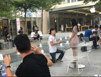 A young man kneels down before his girlfriend in front of an Apple store in Shenzhen City, Guangdong Province. (Photo/China.org.cn)