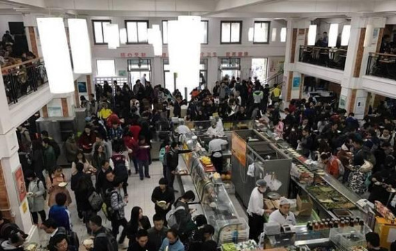 Many students stand to dine at a Peking University dining hall. (Photo/The Beijing News)