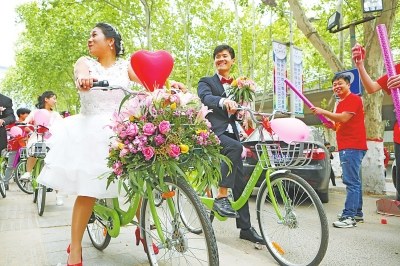 A couple in central China's Henan Province ride shared bikes to celebrate their big day. (Photo/dahe.cn)