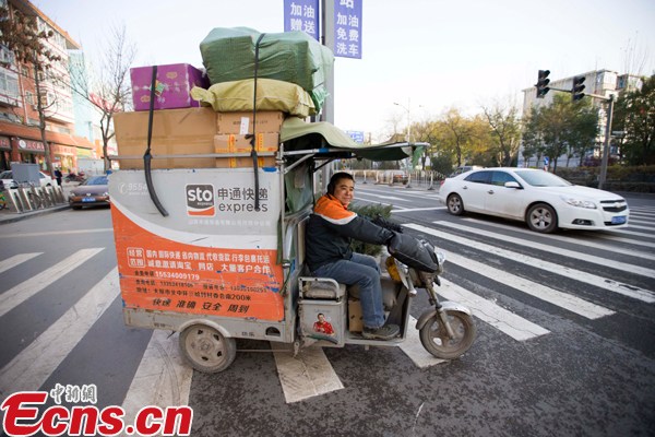 A delivery man with STO Express drives a tricycle to deliver packages. (File photo/China News Service)