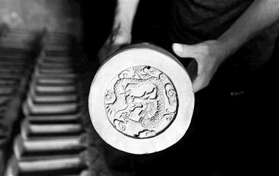 Sun Hongli, the manager of a local glazing factory in Beijing, shows a piece of semi-finished colored glaze. (Photo/Beijing Youth Daily)