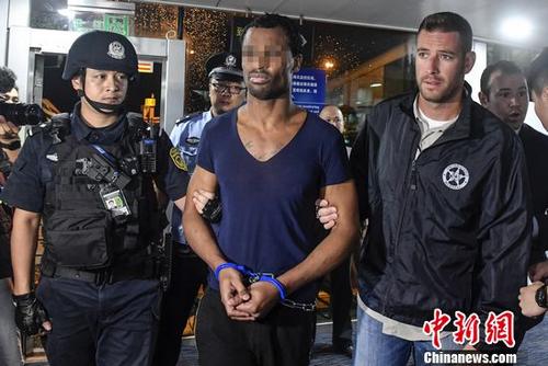 Chinese police transfer Naquan Ferguson, wanted by Interpol for armed robbery, to the U.S. Justice Department at Baiyun International Airport in Guangzhou, Guangdong Province, Aug. 25, 2017. (Photo: China News Service/Chen Jimin)