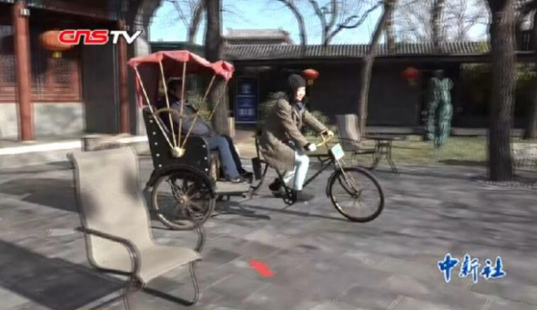 Li Geyin rides a tricycle at a scenic spot in Houhai, Beijing. (Photo/Screenshot from CNS video)