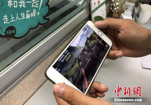 A mobile phone user watches video via cellphone traffic. (Photo/China News Service)