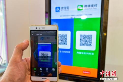A customer scans QR code to pay at a store. (Photo/China News Service)