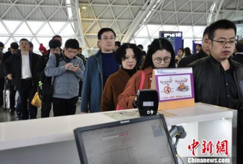 Passengers line up to board a flight. (Photo/China News Service)