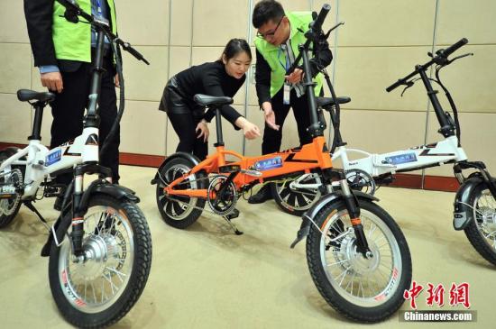 People check e-bikes at a shop. (Photo/China News Service)