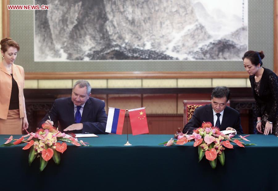 Chinese Vice Premier Wang Yang (front R) and Russian Deputy Prime Minister Dmitry Rogozin (front L) sign a meeting memos after the chairmen meeting of the joint commission for the regular meetings of Chinese and Russian Prime Ministers in Beijing, capital of China, May 19, 2014.