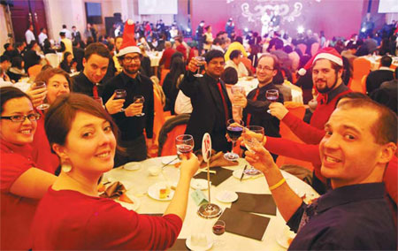 Expats working in Tianjin enjoy a Christmas party in a hotel. The party business is booming in big cities. [Photo/China Daily ]