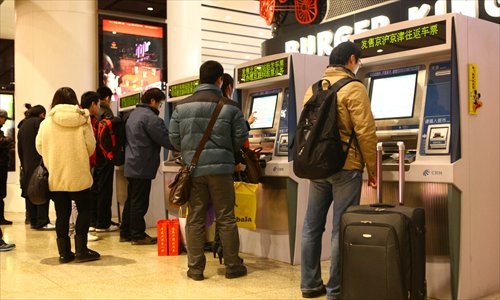 Travelers pay fares at ticket machines at Beijing South Railway Station Sunday. Photo: Guo Yingguang/GT