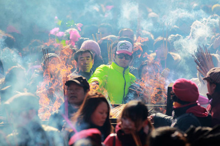 Tens of thousands of people go to pray and burn incense at Yonghe Lama Temple in Beijing during Lantern Festival, which fell on Monday this year. Cui Meng / China Daily 