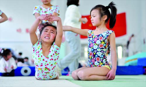 eammates help another with back-bending stretching exercise. (Photo: Cai Xianmin/GT)