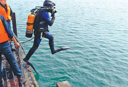 A diver steps into Qiandaohu to explore the submerged Lion City. Photos by Yong Kai / China Daily