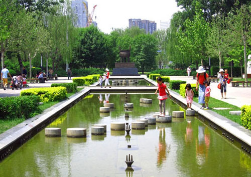Children cross the fountain in Chaoyang Park's Art Square.(Photo source: CRI Online)