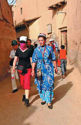 A Uygur guide leads a group of tourists on a walk around the alleys of old Kashgar. Huang Zhe / for China Daily
