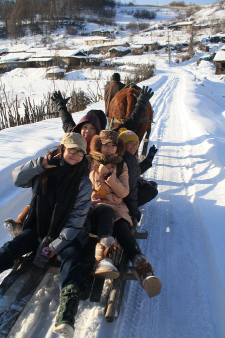 Visitors take a sled to nearby villages with forestry culture. Provided to China Daily