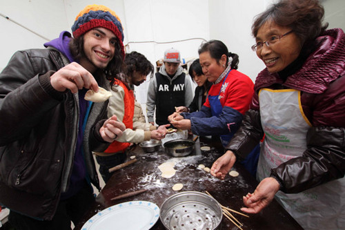 Two young musicians from the United States learn to make dumplings from residents of a community in Nantong, Jiangsu province, on Jan 26.