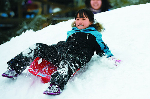 A child plays at a ski resort in Beijing. Light snowfalls are expected in the capital during the Spring Festival holiday, making ski resorts a popular choice to have fun. [WEI XIAOHAO / CHINA DAILY]