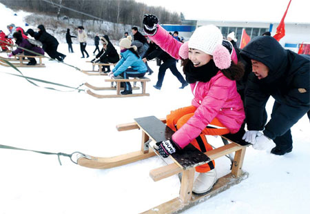 Tourists participate in a sledding competition. Riding a sled is a traditional pastime in rural areas of Northeast China. Liu Bo / for China Daily