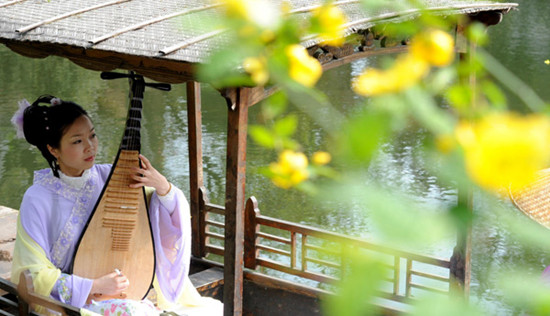 An actress plays Pingtan for visitors at Suzhou Liuyuan Garden in Jiangsu province on April 1, 2013. [Photo / Xinhua]