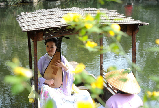 An actress plays Pingtan for visitors at Suzhou Liuyuan Garden in Jiangsu province on April 1, 2013. [Photo / Xinhua]