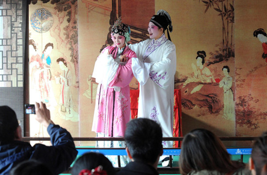 Two actors play Kun Opera for visitors at Suzhou Liuyuan Garden in Jiangsu province on April 1, 2013. [Photo / Xinhua]
