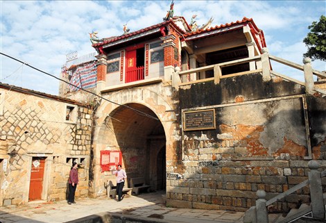Local residents walk under the East Gate of Chongwu township in Quanzhou, a coastal city in eastern Chinas Fujian Province. Chongwu, meaning advocating defense in Chinese, served as a military base against invaders from sea, especially from Japan, since 1387 in Ming Dynasty (1386-1644).
