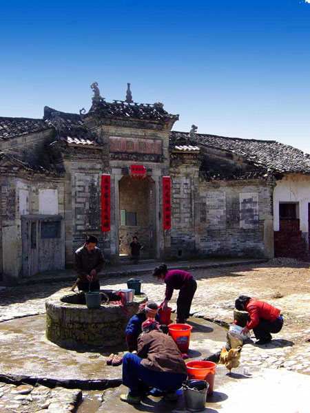 Residents are busy around a well in the Wushi Enclosed House in Longnan.[Photo/Provided to China Daily]