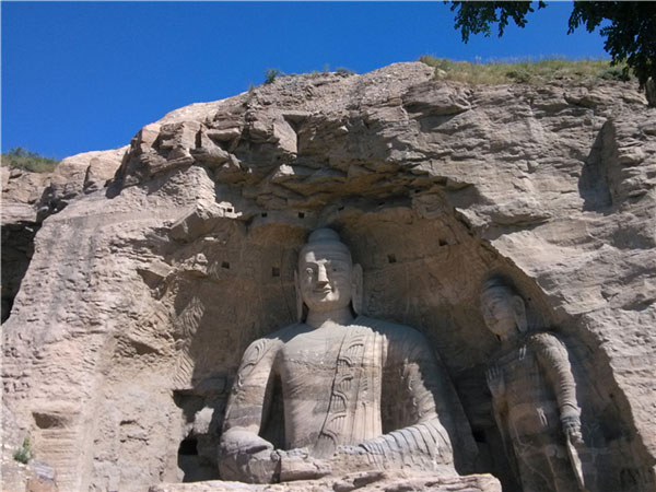 The Buddha, 13.7 meters tall, is treated as a symbol of Yungang Grottoes at Cave No 20. [Photo by Guo Rong/chinadaily.com.cn]