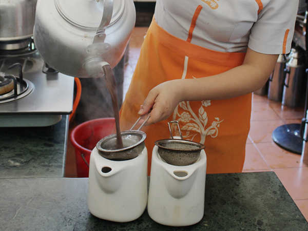 The locals in Hainan province brew coffee in big iron kettles and drain it through cotton fabric or iron filters. [Photo: China Daily] 