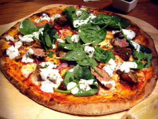 With dollops of mint yogurt and baby spinach, Moroccan lamb pizza is a signature dish at Cafe Deco Pizzeria. (Photo source: China Daily)