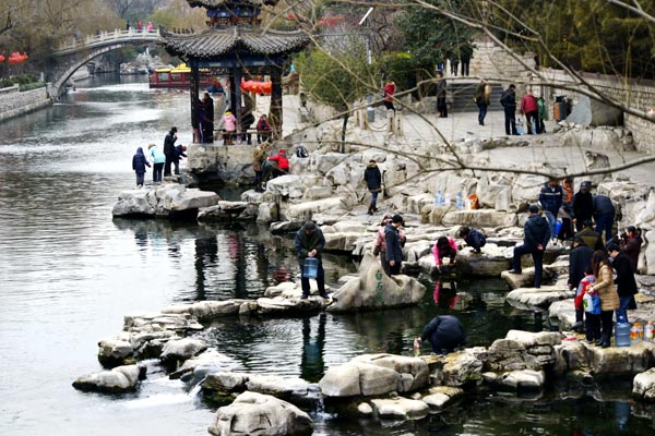 Residents draw water from Baishi (White Stone)Spring in Jinan, Shandong province. [Photo by Ju Chuanjiang/China Daily]