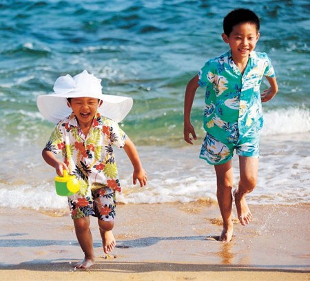 Two children play on a beach in Sanya.  Xinhua