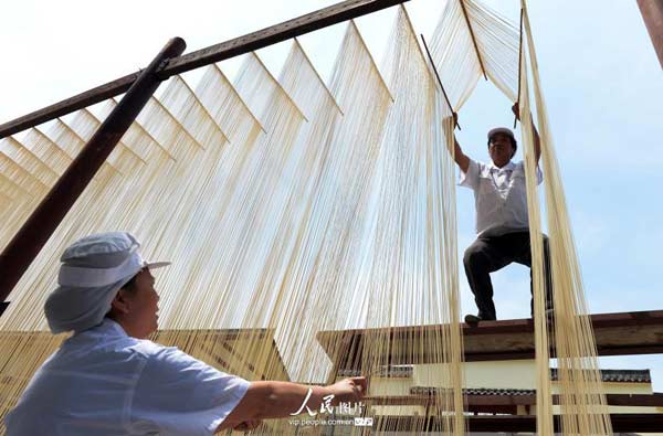 A worker arranges the noodles in a Hakka Kong Fu noodles shop in Nanchong city, southwest Chinas Sichuan province on May 11, 2014. [Photo/People's Daily Online] 