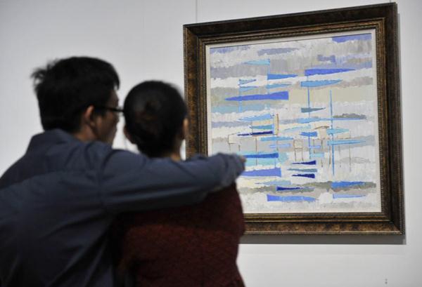 Two visitors appreciate the painting Fishing on the Sea by the French painter Jean Francois Favre at the National Museum in Beijing, August 5, 2014. [Photo/Xinhua]