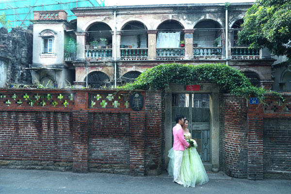 A young couple pose for their pre-nuptial photo shoot at Gulangyu Island in Xiamen. Zhu Xingxin / China Daily