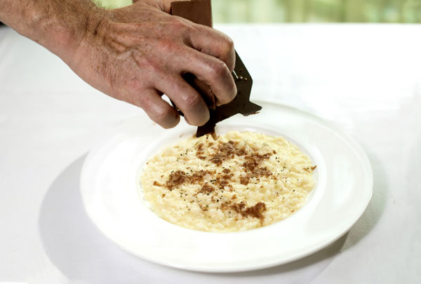 A chef shaves chocolate on top of risotto just before serving during the nine-course chocolate-infused meal at the Ritz-Carlton, Beijing. [Photo provided to chinadaily.com.cn]  