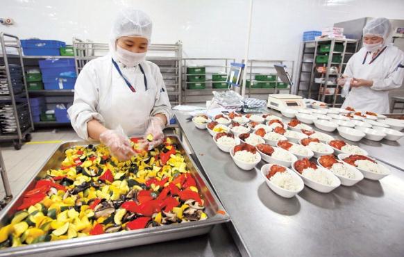A chef at Gate Gourmet Shanghai is plating food for economy class.  Wang Rongjiang/Shanghai Daily