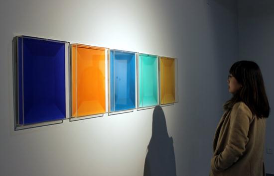 A visitor takes in an artwork on display in Suzhou, Jiangsu province, Dec 25,2014. [Photo by Wang Jiankang/asianewsphoto.com]  