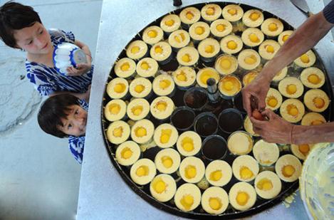 Two children wait at a street-food stand in Kashgar, Xinjiang Uygur autonomous region. Zhang Yi/China Daily