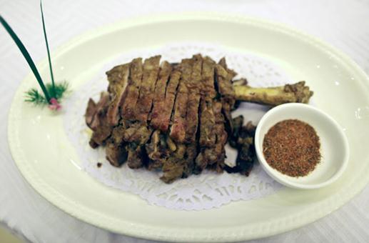 A staff member sells traditional Xinjiang snacks at Kashgar Restaurant, a highly popular Beijing eatery that offers a variety of Xinjiang food including the famous roasted lamb leg. [Photo by Feng Yongbin/China Daily]